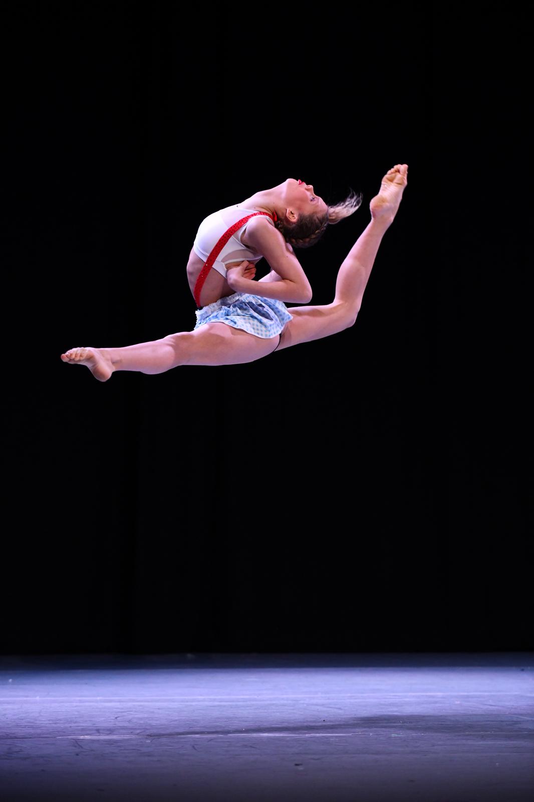 Moondance modern jazz dancer performing a split leap on stage