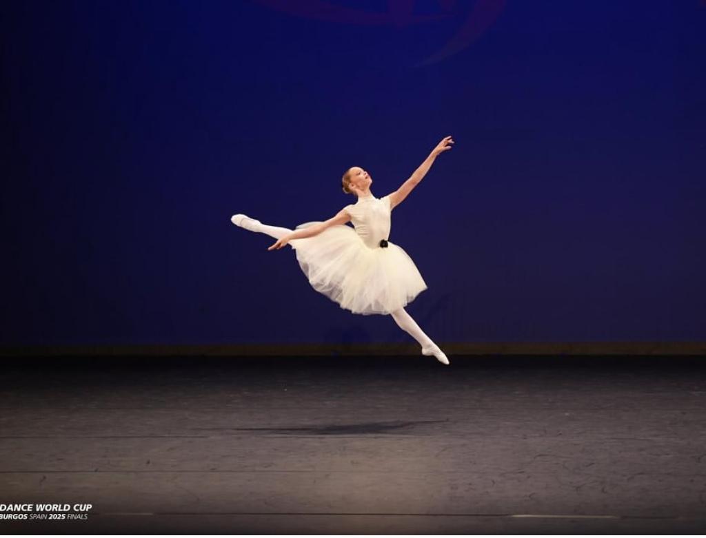 Moondance ballet dancer mid-leap in a white tutu at the Dance World Cup finals