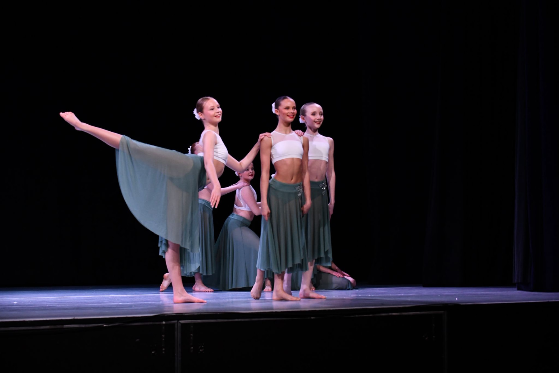 Moondance lyrical group in green skirts holding a final pose